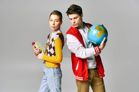 Young male and female students holding a globe in a classroom setting.