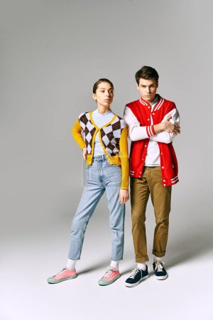 Young male and female students in casual attire strike a pose in a college classroom.