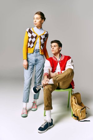 Attractive students pose on a chair in a college classroom.