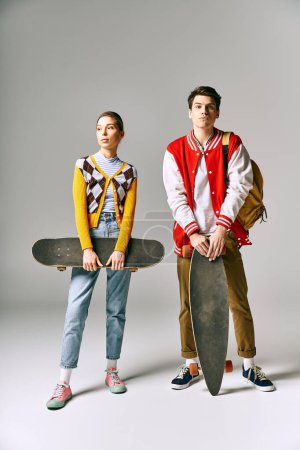 Photo for Two young people hold skateboards against a white backdrop. - Royalty Free Image