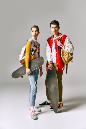 Two students strike a cool pose with skateboards.