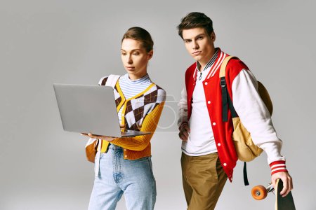 Casual college duo with laptop and skateboard.