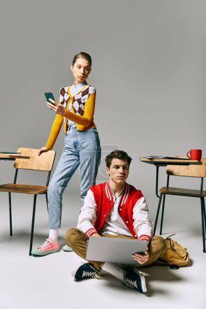Téléchargez les photos : Un jeune homme et une jeune femme s'assoient par terre avec un ordinateur portable, collaborant à un projet. - en image libre de droit