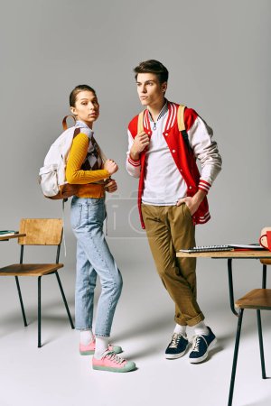 Photo for Two young individuals strike poses in a college classroom setting. - Royalty Free Image