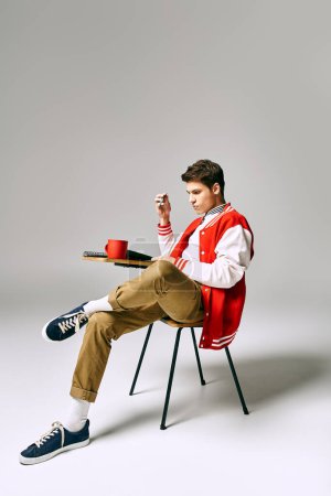 A man in a red jacket sits on a chair.