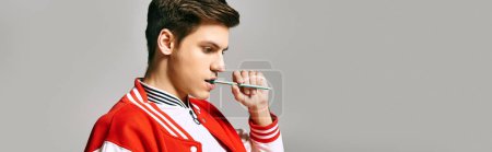 Photo for A man in a red jacket posing in college with pen in hand. - Royalty Free Image