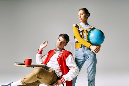 Un homme et une femme étudiants assis tenant un globe, profondément dans la pensée et l'émerveillement.