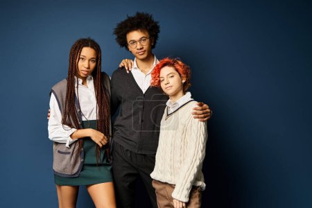 Multicultural friends, including a nonbinary person, standing together stylishly on a dark blue background.