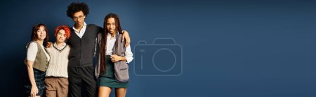 Photo for Young multicultural friends, including a nonbinary individual, stand together in stylish attire on a dark blue background. - Royalty Free Image