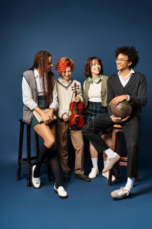 Eine Gruppe junger multikultureller Freunde posiert in stylischer Kleidung vor dunkelblauem Hintergrund für ein Foto.