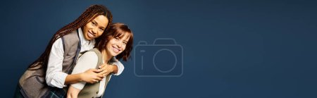 Photo for Young friends, standing together in stylish attire, hugging each other. - Royalty Free Image