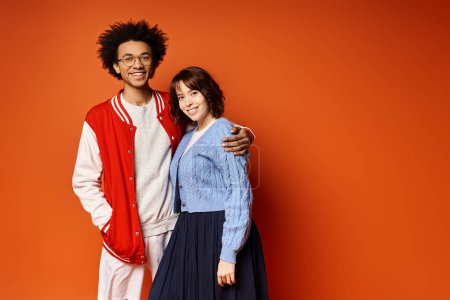 A man and a woman, along with a nonbinary person, stand together in stylish attire in a studio setting, portraying unity and friendship.