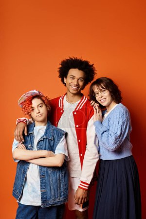Groupe diversifié de jeunes amis, y compris un individu non binaire, debout ensemble dans une tenue élégante dans un cadre de studio.