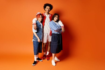 A diverse group of young friends, including a nonbinary person, stand together in stylish attire in a studio setting.