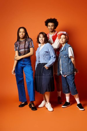Eine Gruppe junger multikultureller Freunde, darunter eine nicht binäre Person, steht in stilvoller Kleidung in einem Studio-Ambiente zusammen.