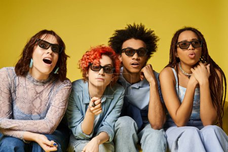 Multicultural group in sunglasses sitting together in stylish attire in a studio setting.