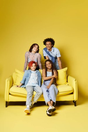Multicultural friends relax on a bright yellow couch in a stylish studio setting.