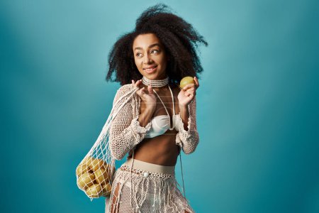 Photo for Stylish woman with curly hairstyle holding bag of apples. - Royalty Free Image