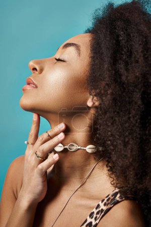 Téléchargez les photos : Jeune femme afro-américaine avec coiffure bouclée frappant une pose à la mode. - en image libre de droit