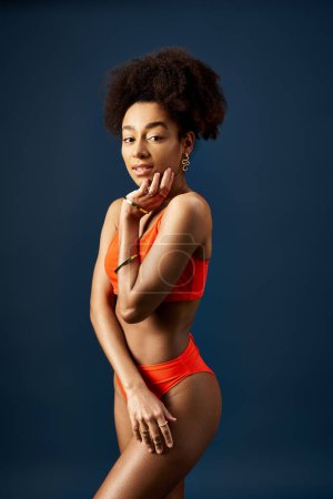 Photo for Stylish young woman with a sun-kissed glow and trendy swimsuit poses confidently. - Royalty Free Image