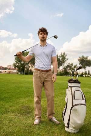 Un hombre con un atuendo elegante se encuentra en un campo de golf con una bolsa de golf, que encarna un estilo de vida antiguo y de clase alta.
