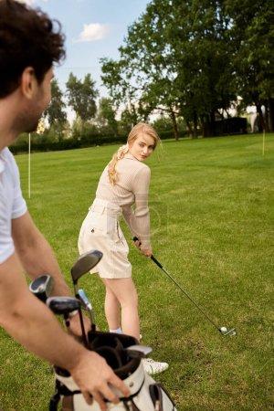Ein Mann und eine Frau in eleganter Kleidung spielen eine Runde Golf auf einem üppigen Platz und zeigen ihre Fähigkeiten, während sie das Spiel genießen.