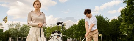Téléchargez les photos : A young couple in stylish attire plays a round of golf in a park, enjoying a leisurely day together on the green. - en image libre de droit