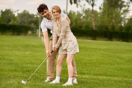 A man and woman in elegant attire playing golf on the lush green field of a golf club.