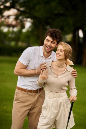 Foto de Un hombre y una mujer con estilo posan en un pintoresco entorno de parque, encarnando sofisticación atemporal y romance. - Imagen libre de derechos