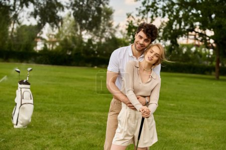 A stylish man and woman are posing elegantly on a golf course, exuding sophistication and class in their attire.