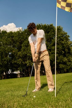 Ein Mann in eleganter Kleidung schwingt einen Golfschläger und schlägt einen Ball auf einem Rasenplatz in einem Golfclub.