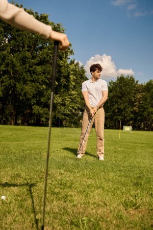 Photo for A stylish young couple enjoy a game of golf on a lush green field in a luxurious setting. - Royalty Free Image