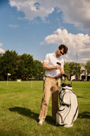 A man in elegant attire stands gracefully beside his golf bag on a lush green field at an upscale golf club.
