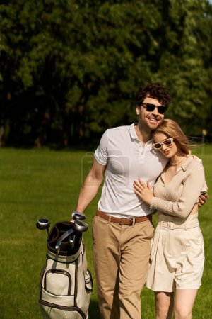 Ein Mann und eine Frau posieren elegant gekleidet für ein Foto auf einem üppig grünen Golfplatz und genießen einen anspruchsvollen Tag.