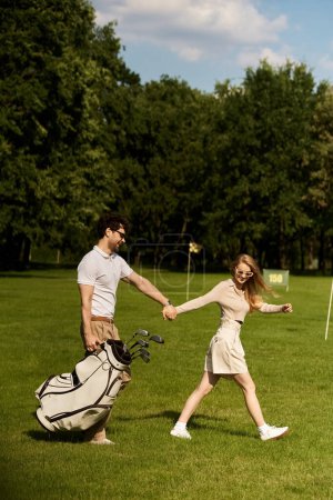 A stylish couple in elegant attire hold hands while walking leisurely on a manicured golf course.