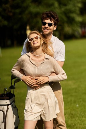 Ein elegantes junges Paar umarmt sich leidenschaftlich auf einem üppig grünen Golfplatz und verkörpert Luxus und Romantik in idyllischer Umgebung.