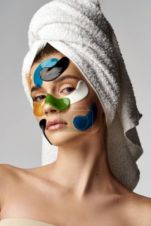 A young woman with eye patches on her face, wearing a towel on her head in a serene pose.
