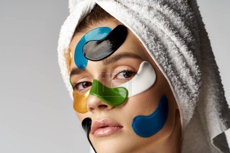 Une femme avec une serviette sur la tête, avec des patchs sur le visage.