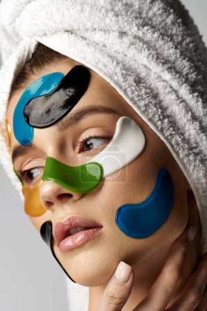 Téléchargez les photos : Une femme avec une serviette sur la tête et des bandeaux sur le visage, présentant une routine beauté sereine et transformatrice. - en image libre de droit