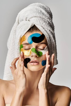 Una joven serena y elegante con parches en la cara, mostrando una rutina de belleza con toallas envueltas alrededor de su cabeza.