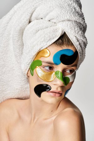 Attractive young woman with a towel wrapped around her head and eye patches.