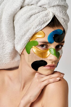 Foto de Una mujer con una toalla en la cabeza con manchas en los ojos en la cara. - Imagen libre de derechos