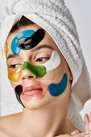 Une femme étonnante posant doucement avec une serviette sur la tête et ornée de bandeaux oculaires.
