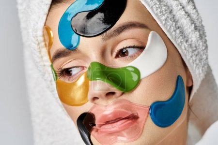 Une jeune femme avec des patchs sur le visage, serviette enveloppée sur sa tête, exsudant beauté et art.