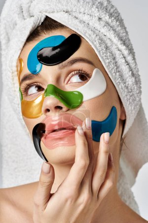 Foto de Una mujer serena con una toalla en la cabeza y parches en los ojos, exudando relajación y cuidado personal. - Imagen libre de derechos