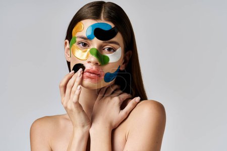 Eine schöne junge Frau mit Augenklappen im Gesicht, die Kunst und Schönheit in einer kreativen Ausstellung vereint.