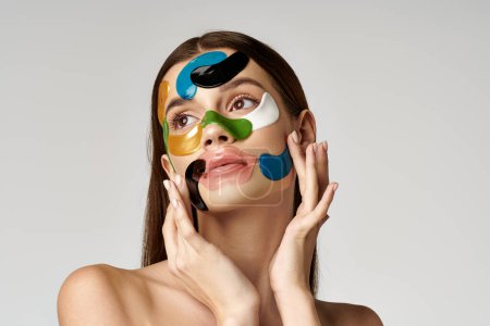 Eine schöne junge Frau mit Augenklappen auf dem Gesicht in leuchtenden Farben, die Kreativität und Selbstausdruck zur Schau stellt.