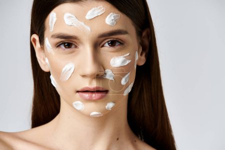A beautiful young woman posing with a thick layer of cream on her face, creating a luxurious and dreamy look.