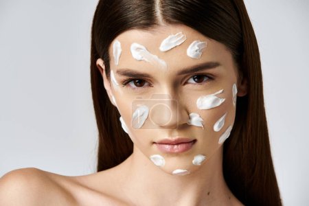 A woman adorned with a generous amount of cream on her face, exuding freshness and beauty.