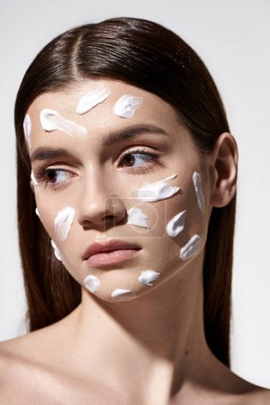 Eine junge Frau strahlt Schönheit aus, mit einer weißen Creme im Gesicht, die ihre Gesichtszüge betont.